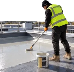 RESTEC trained installer rolling a liquid roofing coat in hi-vis and gloves